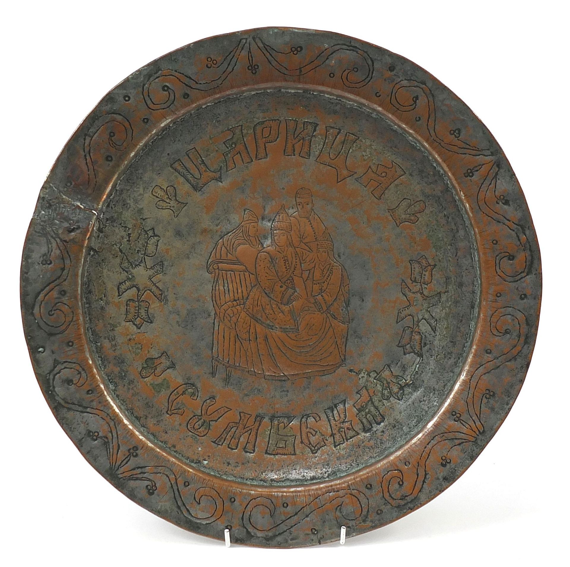 Russian coppered marriage plate engraved with figures and script, 39.5cm in diameter