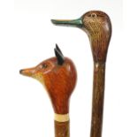 Two naturalistic carved wood crooks with duck and fox design handles, the largest 128cm in length