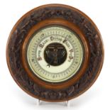 Circular walnut wall barometer carved with oak leaves and acorns, 23.5cm in diameter