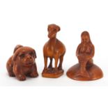 Three Japanese carved wood netsukes including mermaid and puppy, the largest 5.5cm high