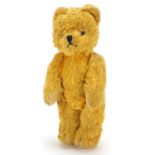 Antique straw filled golden teddy bear with articulated limbs and hump back, 21cm high
