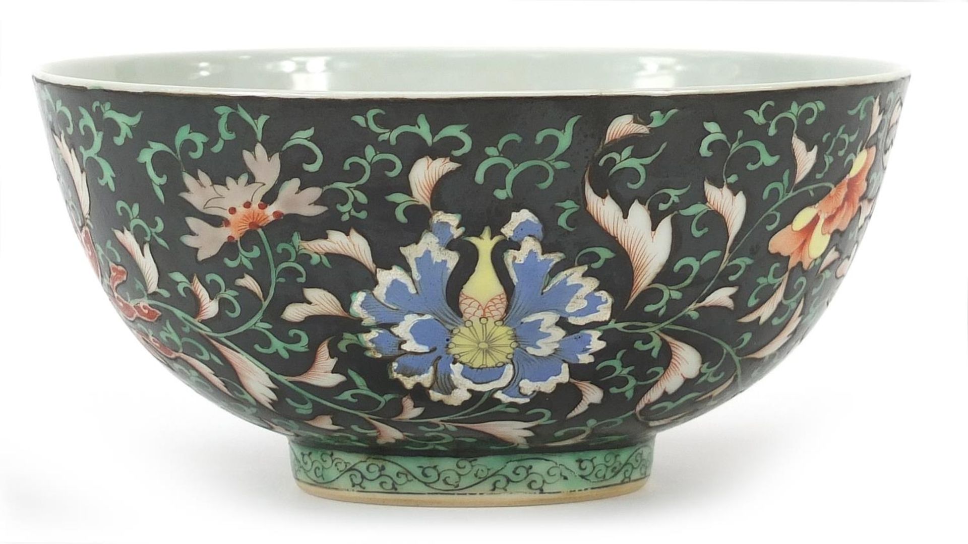 Chinese porcelain bowl hand painted in the famille noire palette with flower heads amongst scrolling