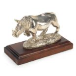 Afrisilver, African sterling silver filled rhinoceros, raised on a wooden base, 16cm in length