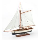 Wooden model yacht on stand with canvas sails, 59cm in length
