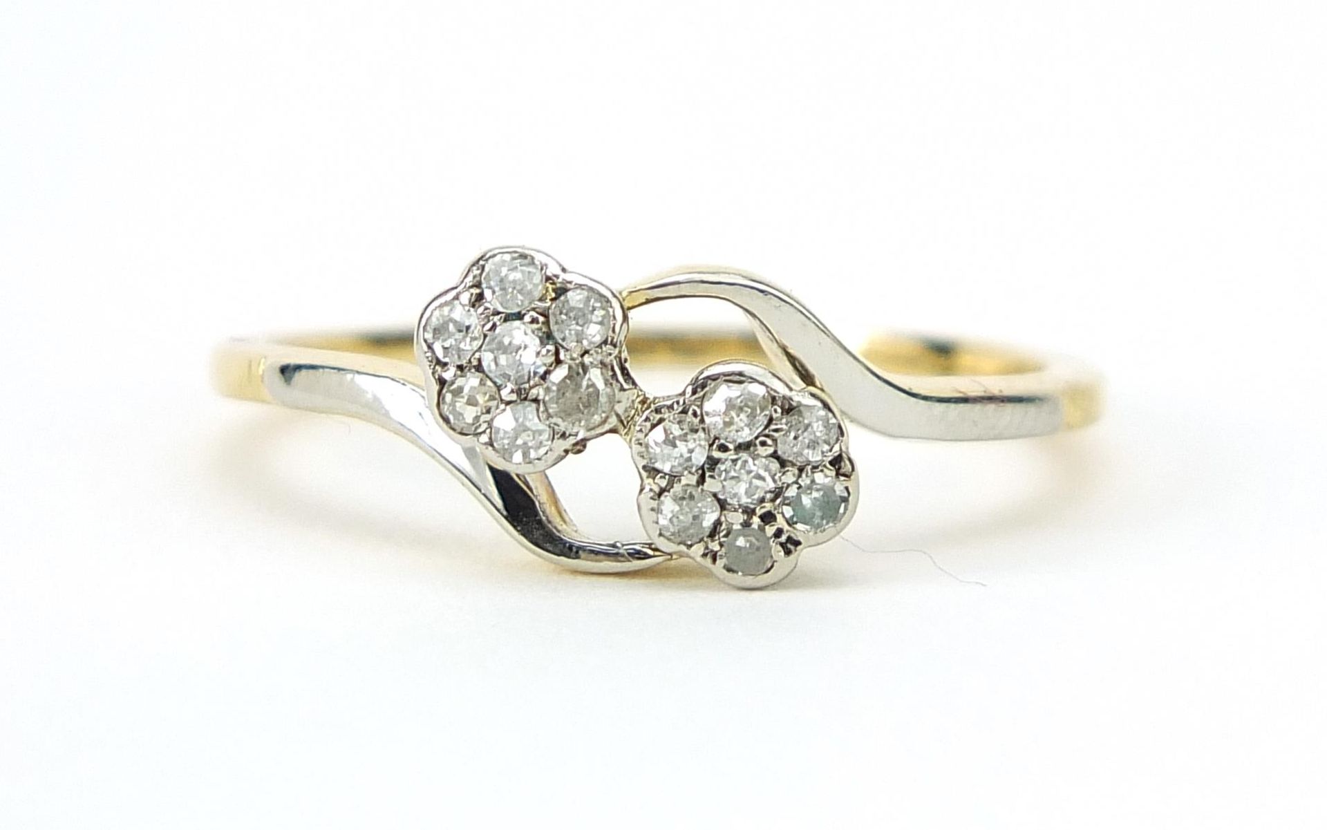 Unmarked gold and platinum diamond flower head crossover ring, size P, 2.5g