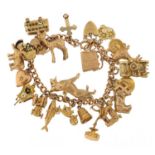 9ct gold charm bracelet with a large selection of mostly 9ct gold charms including Alsatian dog,