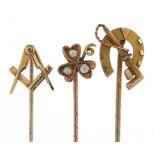 Three Victorian and later gold stick pins including masonic and a horseshoe with riding crop