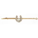 Unmarked gold diamond and pearl horseshoe bar brooch, the largest diamond approximately 0.11ct,