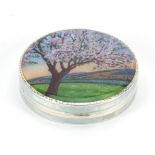 Circular silver compact enamelled with a tree before rolling hills, London import marks 1928, 5cm i