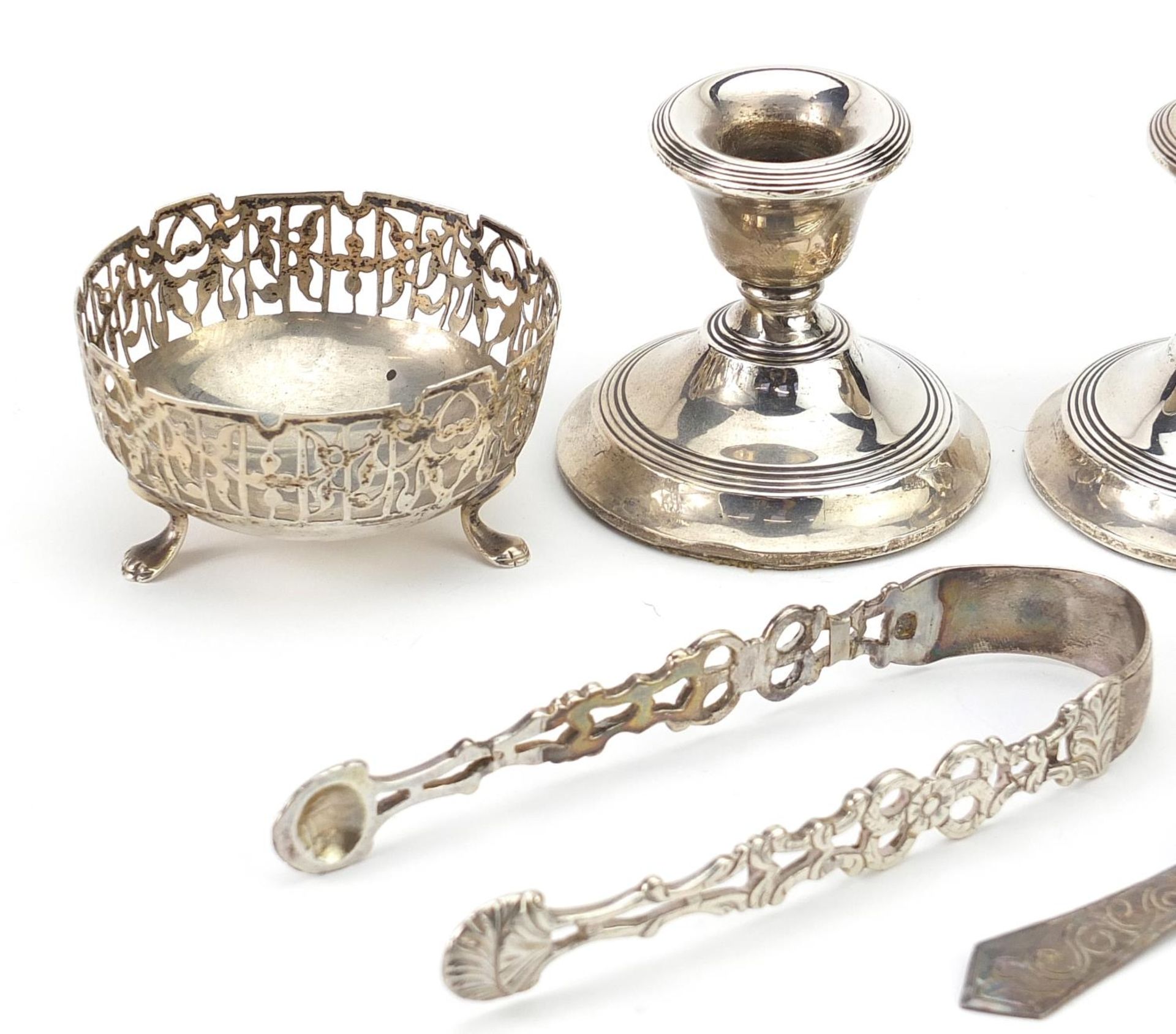 Silver objects comprising pair of dwarf candlesticks, pair of open salts, sugar tongs and a spoon, - Image 2 of 5