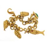 18ct gold charm bracelet with a selection of gold charms including enamelled seahorse, drum with