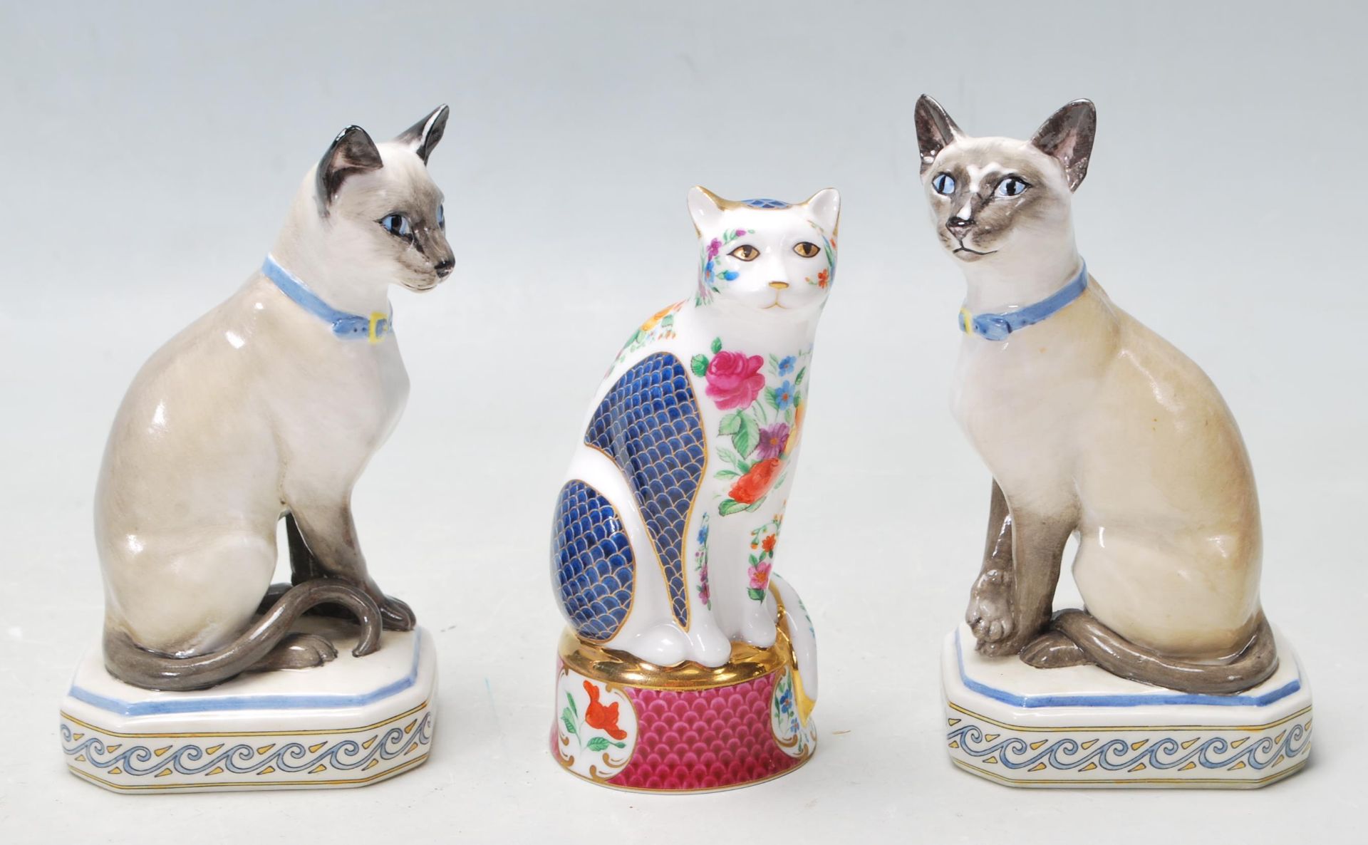 THREE CAT FIGURINES BY ROYAL WORCESTER AND HALCYON DAYS TO INCLUDE THE SIAMESE CAT AND GILES CAT.