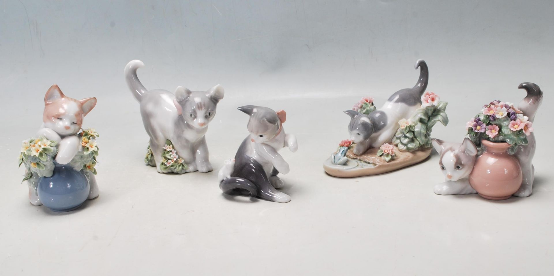 A COLLECTION OF LLADRO FIGURINES IN THE FORM OF CATS PLAYING.