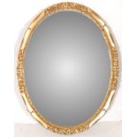 A 20TH CENTURY ANTIQUE STYLE OVAL MIRROR WITH BEVELLED GLASS