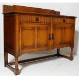 1930S OAK SIDEBOARD WITH CARVED PANELS AND BRASS SWING HANDLES.