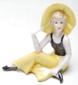 ART DECO 1930S STYLE CERAMIC FIGURINE OF A SEATED FLAPPER GIRL