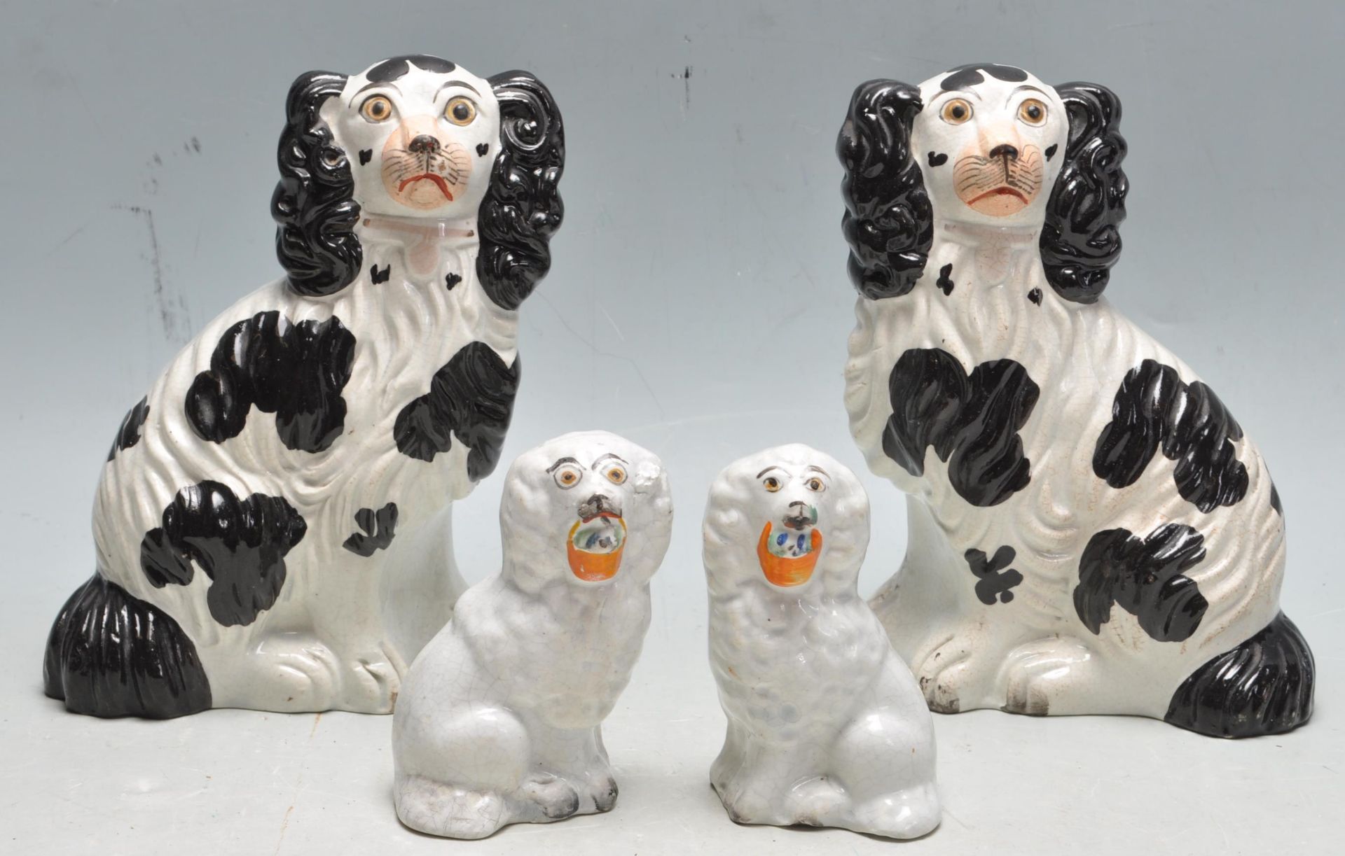TWO PAIRS OF CERAMIC ANTIQUE STAFFORDSHIRE SPANIEL DOGS