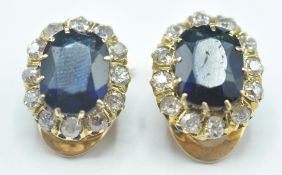 A pair of 14ct gold clip on, blue stone and diamond earrings. The earrings having as central stone