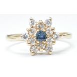 9CT GOLD BLUE AND WHITE STONE FLOWER HEAD RING