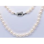 AN 18CT GOLD SAPPHIRE SINGLE STRAND PEARL NECKLACE