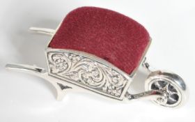 STAMPED STERLING SILVER PIN CUSHION IN THE FORM OF A WHEEL BARROW.