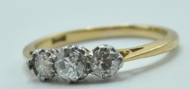 STAMPED 18CT GOLD ENGAGEMENT RING WITH A ROW OF THREE DIAMONDS.