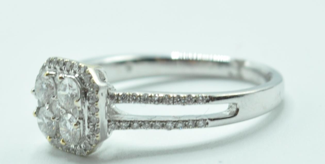 STAMPED 18K WHITE GOLD AND DIAMOND CLUSTER RING.