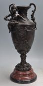 BRONZE TWIN HANDLED VASE ON A STEPPED MARBLE BASE.