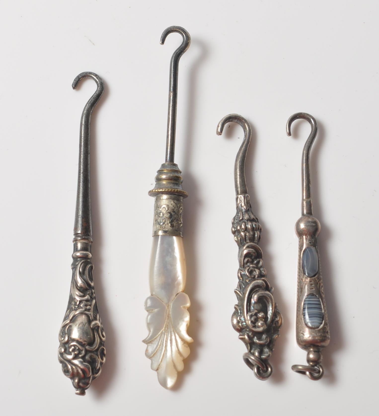 COLLECTION OF FOUR VICTORIAN SILVER BUTTON HOOKS WITH AGATE AND MOTHER OF PEARL HANDLES.