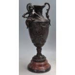 BRONZE TWIN HANDLED VASE ON A STEPPED MARBLE BASE.