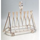 SILVER PLATED TOAST RACK IN THE FORM OF A ROW OF CROSSED CRICKET BATS.