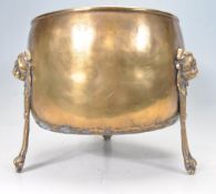EARLY 20TH CENTURY BRASS PLANTER WITH LION HEAD MOTIFS.