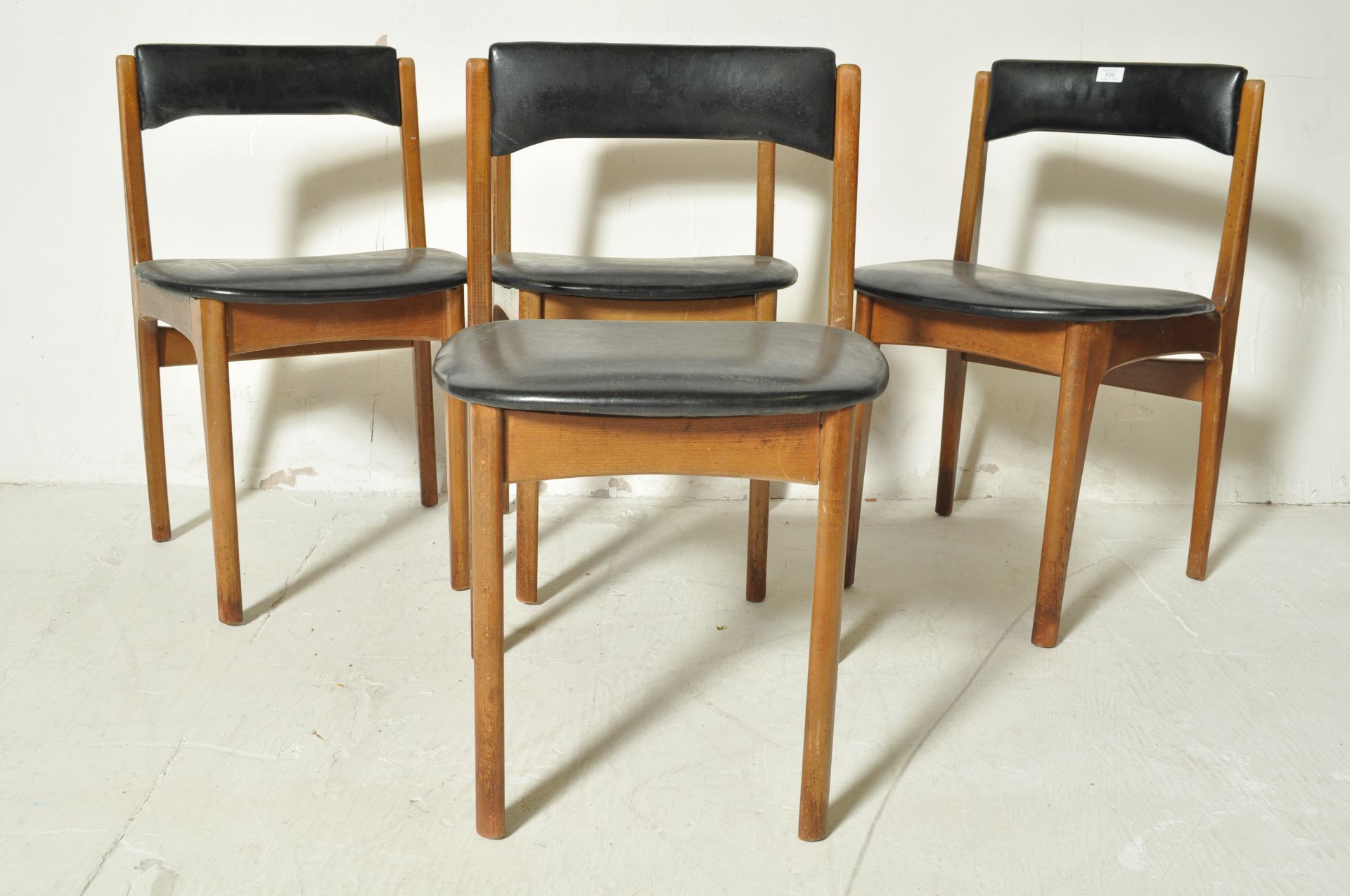 FOUR DANISH INSPIRED TEAK WOOD AND BLACK VINYL DINING CHAIRS