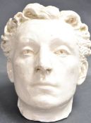 20TH CENTURY NATURALISTIC GLAZED PLASTER BUST OF A YOUNG MAN.