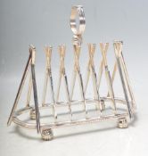 SILVER PLATED TOAST RACK IN THE FORM OF A ROW OF CROSSED CRICKET BATS.