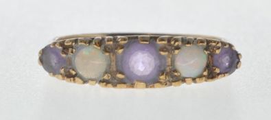 9CT GOLD RING SET WITH OPAL CABOCHONS AND PURPLE STONES.