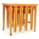 MID CENTURY FOLDING NEST OF TABLES IN THE MANNER OF POUL HUNDEVAD