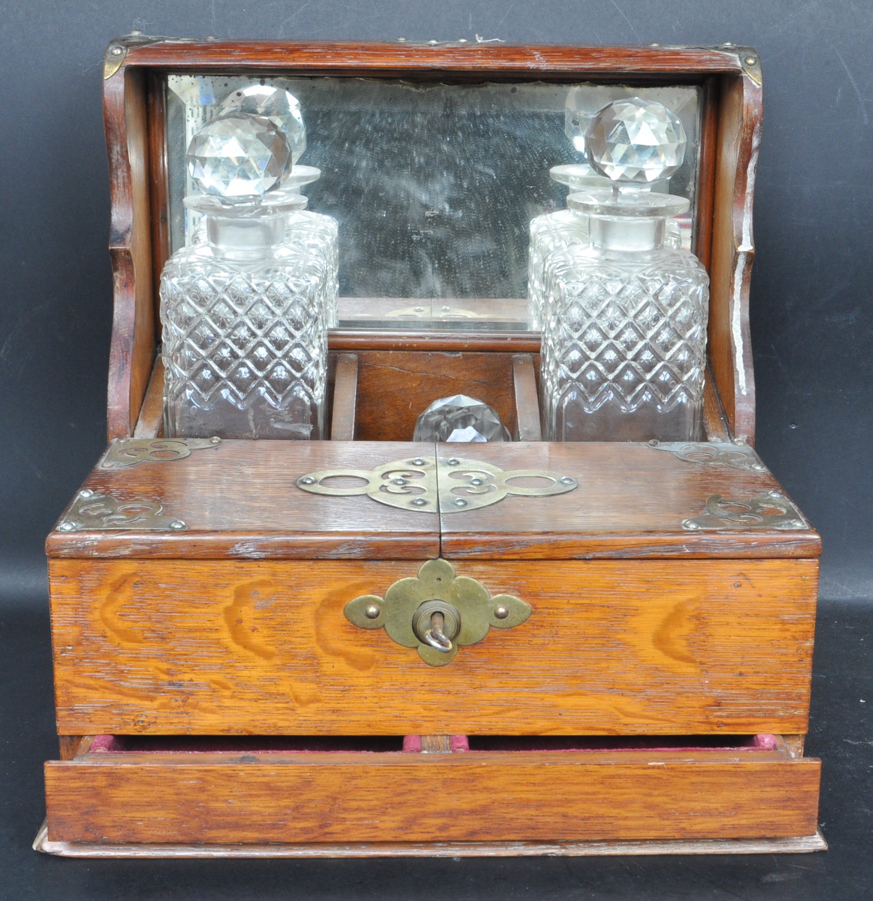 EARLY 20TH CENTURY OAK TANTALUS WITH GLASS DECANTERS