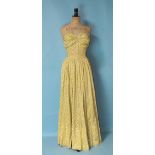 A vintage polka dot yellow and white cotton full-length strapless dress with ruched and boned