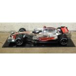 A plastic display model of McLaren Mercedes MP4-22 F1 racing car, 60cm, on plinth with Perspex