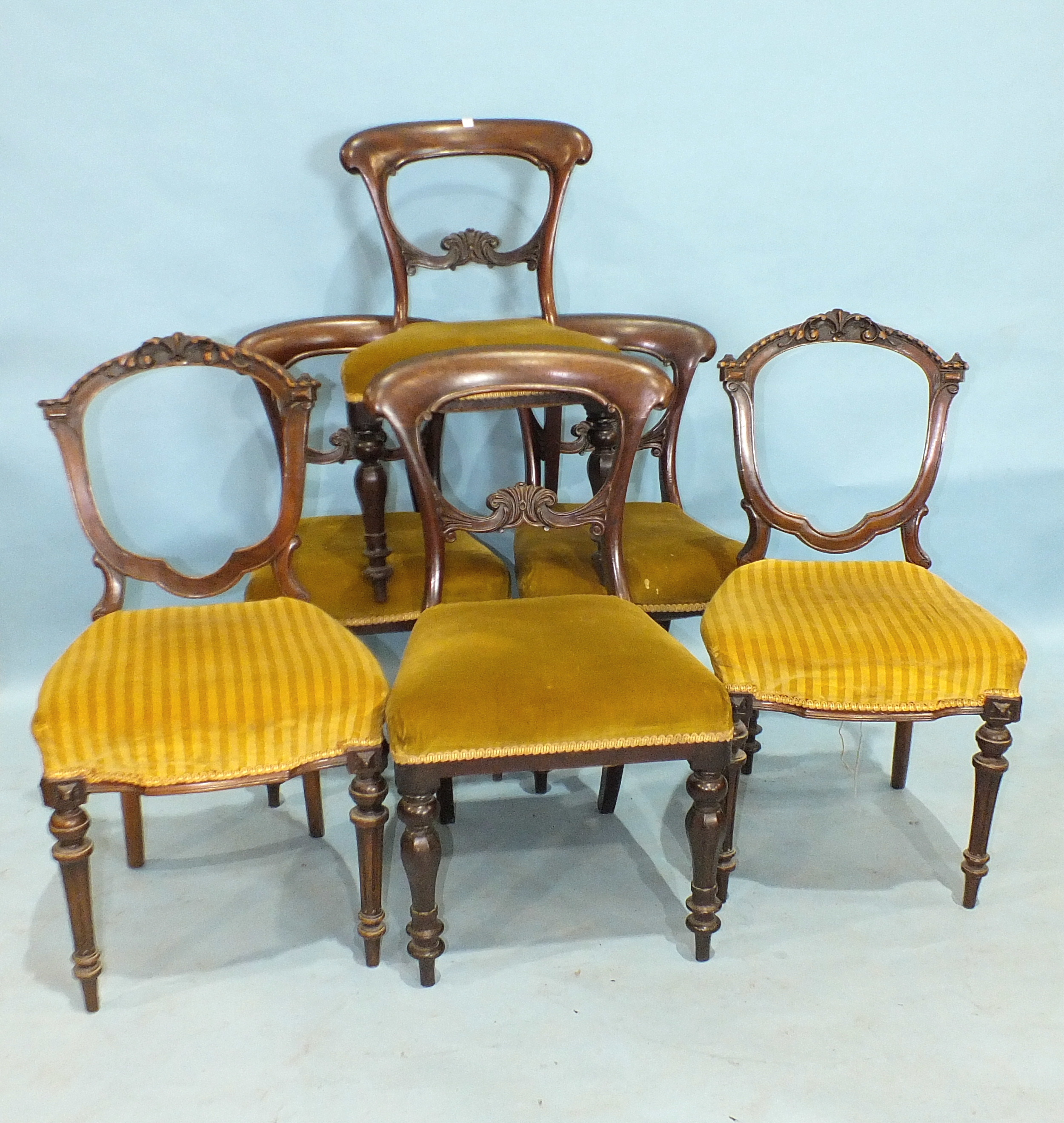 A set of four Victorian balloon-back dining chairs with carved backs, on octagonal turned legs and