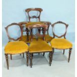 A set of four Victorian balloon-back dining chairs with carved backs, on octagonal turned legs and