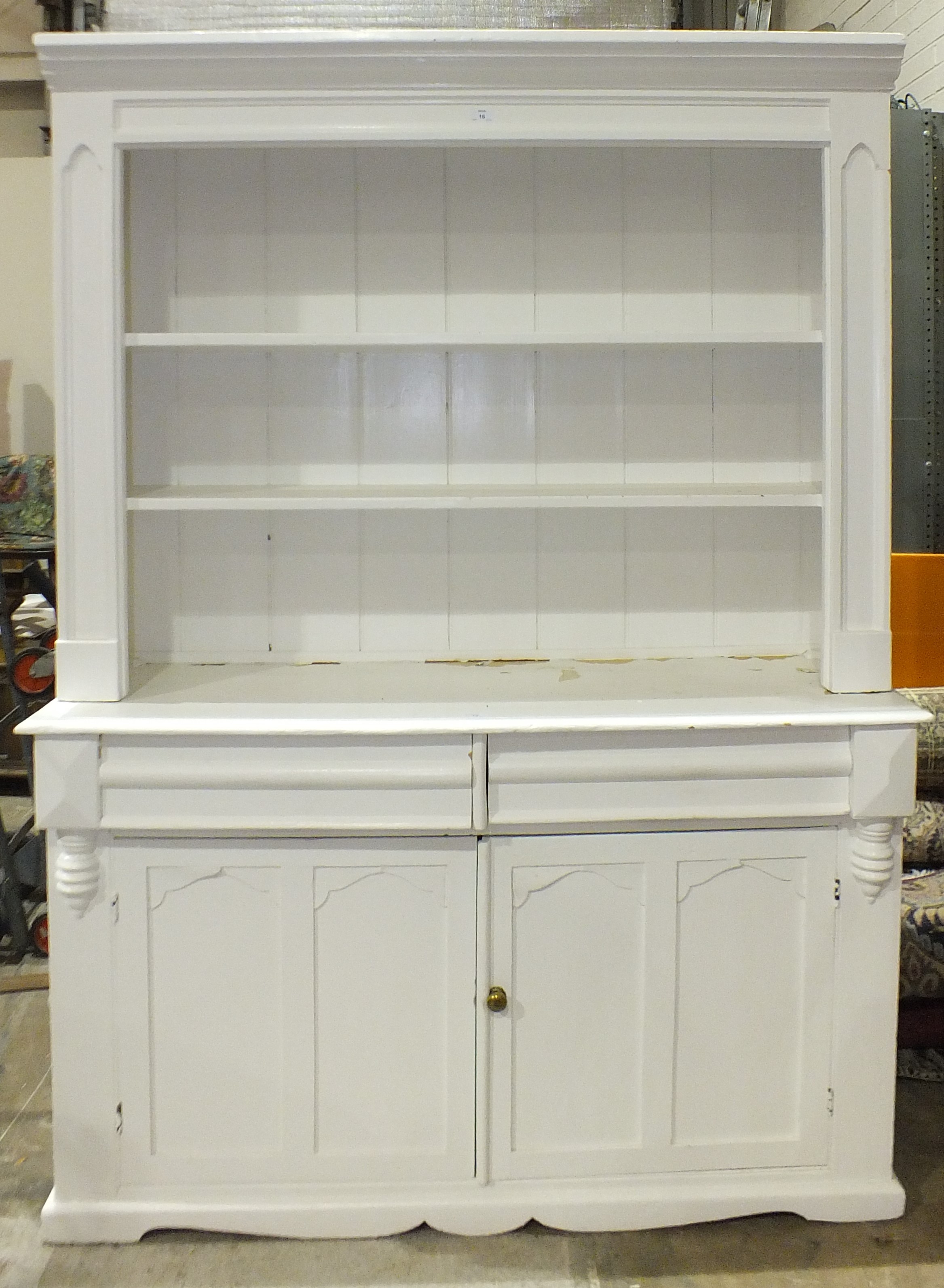 A Victorian white-painted pine dresser, the open shelves above two drawers and two cupboard doors,