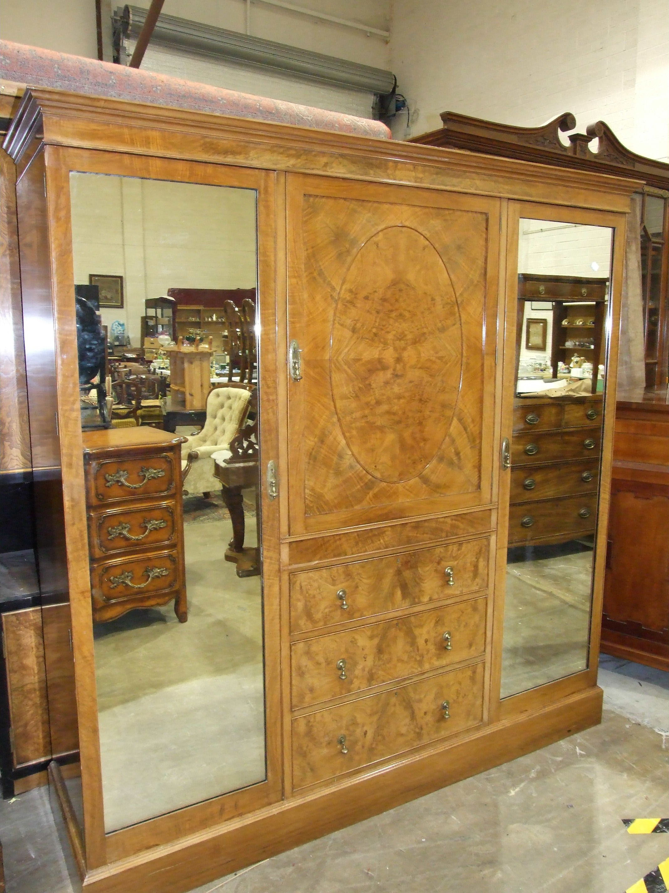 A Heal & Son Ltd walnut sectional wardrobe with central shelves and drawers flanked by mirrored