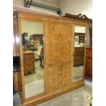 A Heal & Son Ltd walnut sectional wardrobe with central shelves and drawers flanked by mirrored