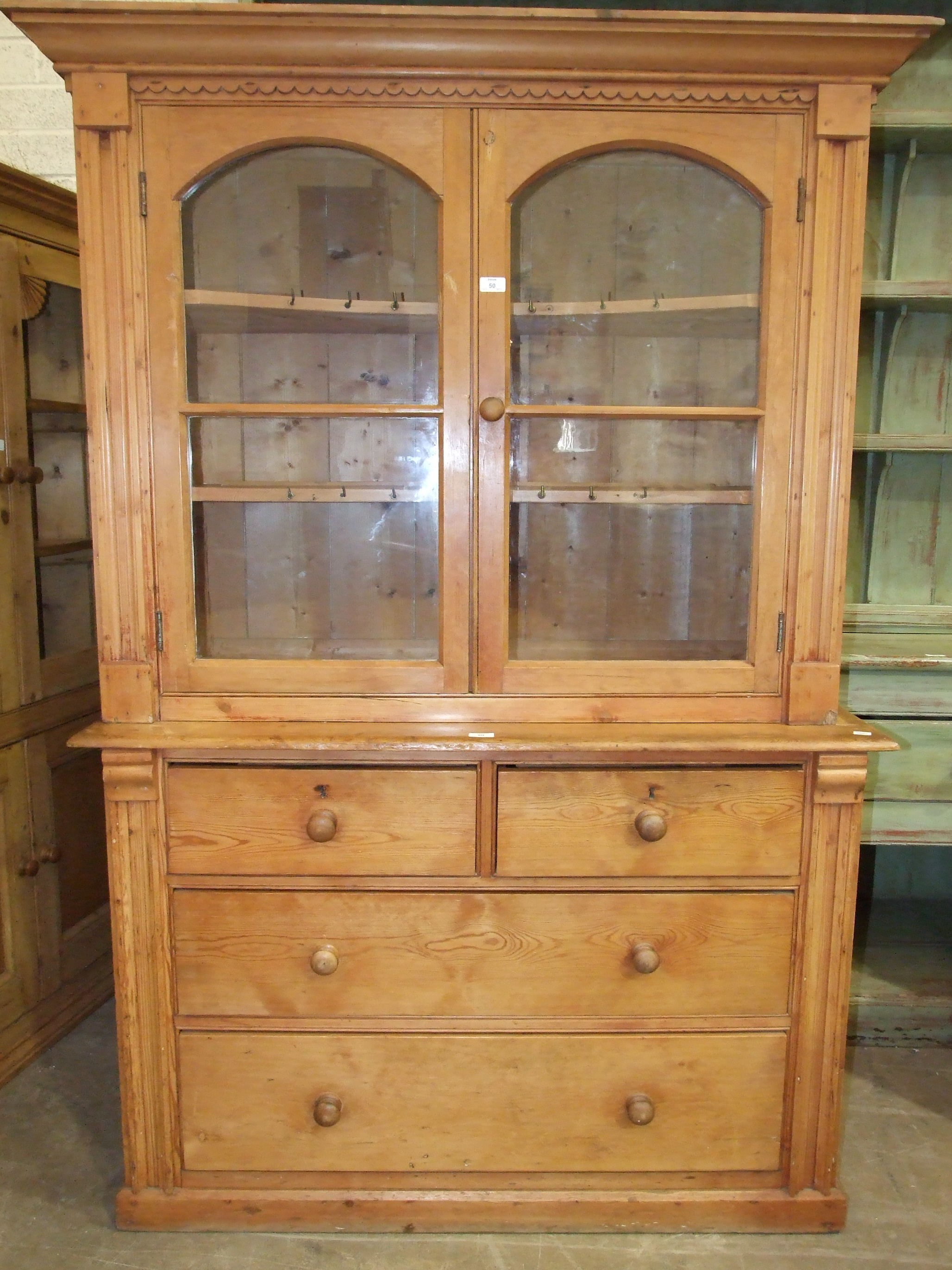 A pine dresser, the shelved upper section fitted with a pair of glazed doors above two short and two