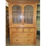 A pine dresser, the shelved upper section fitted with a pair of glazed doors above two short and two