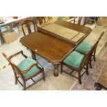 A large early 20th century oak extending dining table, the top with three spare leaves on turned