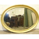 An oval gilt framed bevelled wall mirror, 73 x 100cm.