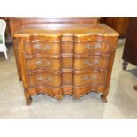 A Continental reproduction stained pine serpentine chest of three long drawers, 117cm wide, 94cm